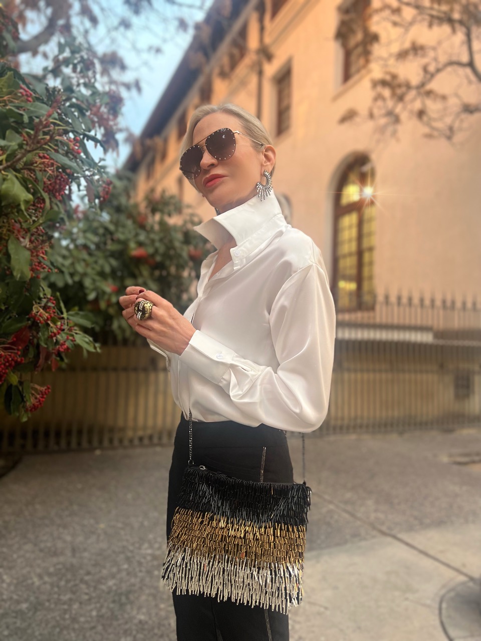Lifestyle influencer, Jamie Lewinger of More Than Turquoise carrying beaded fringe clutch from Chicos 